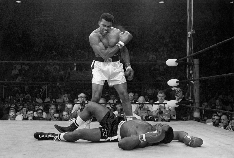 Muhammad Ali stands over a “defeated” Sonny Liston, 1965. Photo by John Rooney/AP